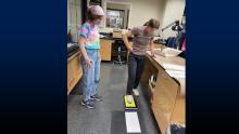 Alyssa Dosemagen (left) and Danielle Baier (right) practice using an ink pad to create a footwear impression during a training session.