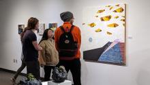 Three students looking at artwork in a gallery