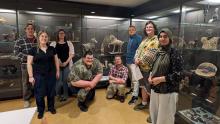 Group of students and faculty standing in front of glass display cases at the UW Chazen Museum