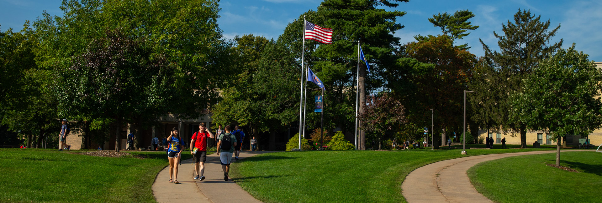 Students walking with flags in the background