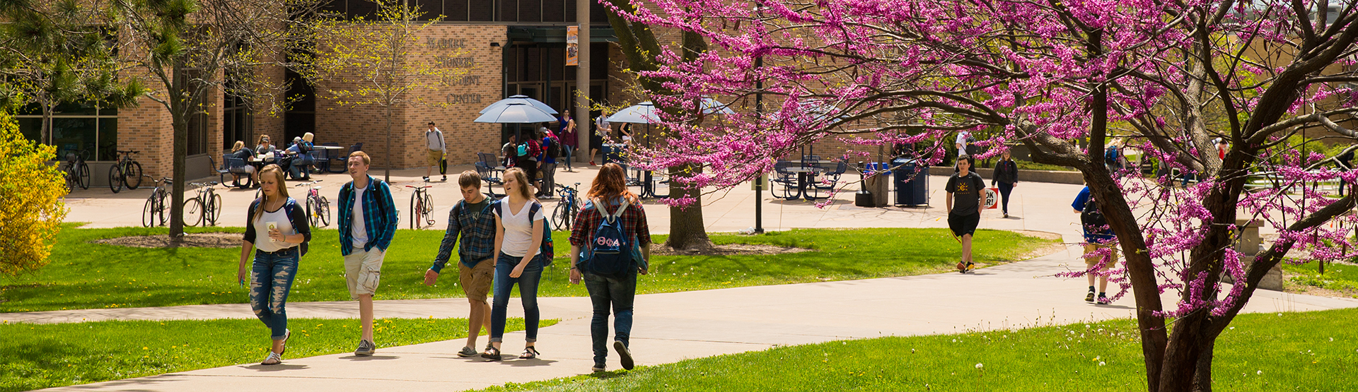 Spring campus students walking outside of Markee Pioneer Student Center