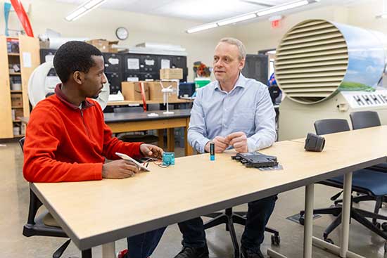 UW-Platteville student discusses solar energy in the lab with a faculty member.