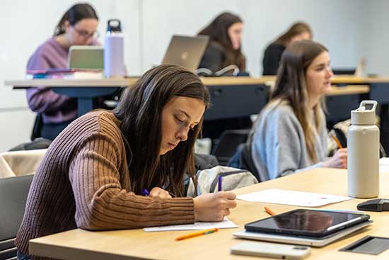 UW-Platteville student takes notes while in lecture.