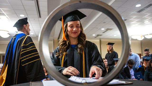 Graduating UW-Platteville student smiles as she completes the Order of the Engineer ceremony.