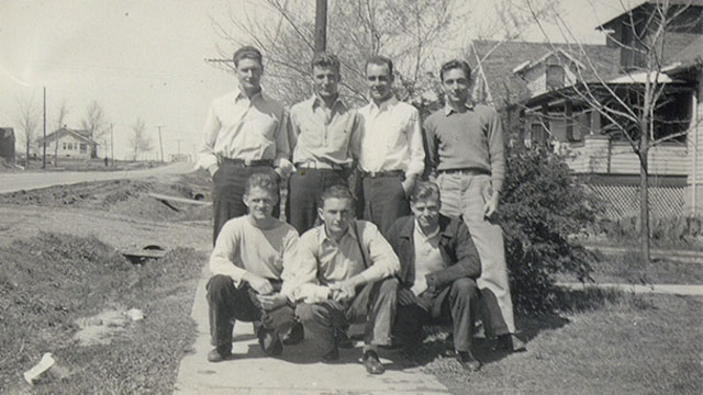 Six students stand in group for photo in rural setting.