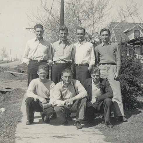Six students stand in group for photo in rural setting.
