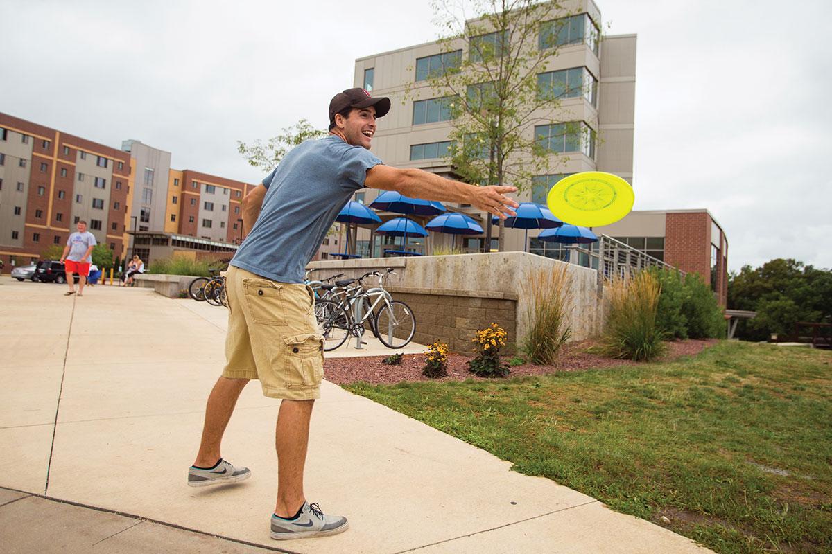 Student playing frisbee outside of Southwest Hall