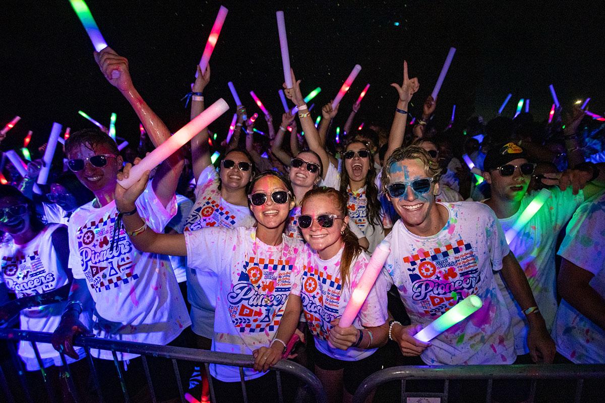 Two UW-Platteville students in orange shirts holding welcome signs on move in day
