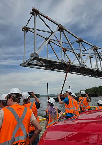 Individuals in orange safety vests on a ferry