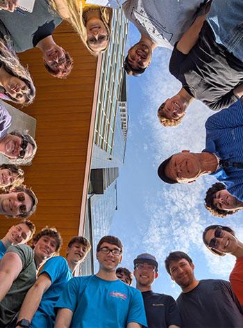 Selfie of students and faculty standing in a circle