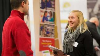 student talking to exhibitor at a career day