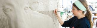 Student working with a sculpture