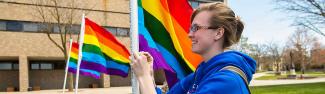 Student hanging pride flag