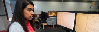 A computer science student coding in computer lab