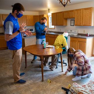 A group of students investigating a mock crime scene