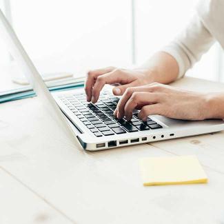 Student typing on laptop