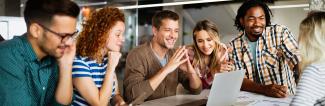Young professionals in meeting around laptop