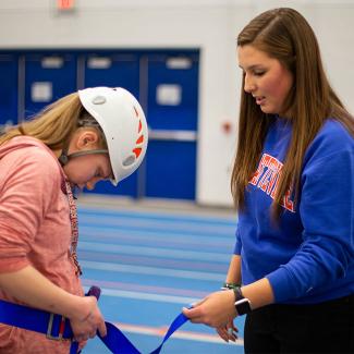 Student helping with harness