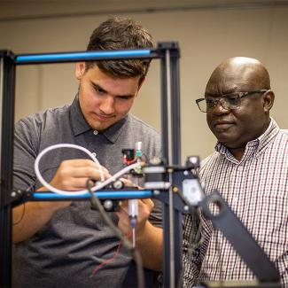 Students working in an engineering lab with prof. John Obielodan