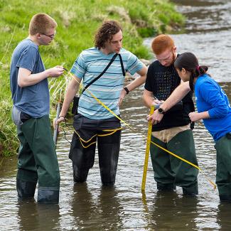 student and faculty working in field