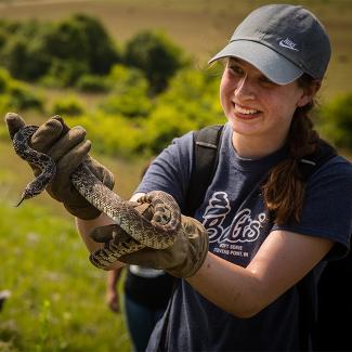 Student holding a large snake