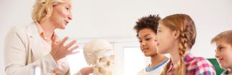 Young students learning biology from professor