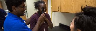 Optometry worker giving eye exam
