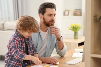 online student working with son next to him
