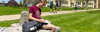 UW-Platteville student reading outside