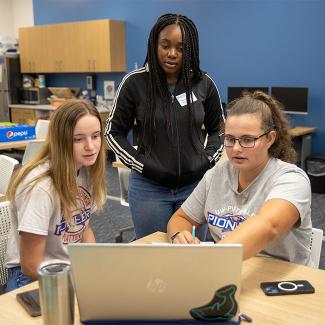 student talking in front of laptop