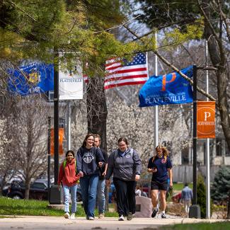 students walking across campus with UW-Platteville flags in background