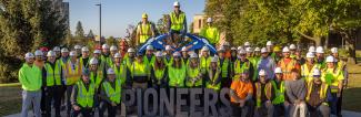 UW-Platteville construction management students in front of Pioneers sign on campus