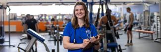 UW-Platteville student in weight room with clipboard