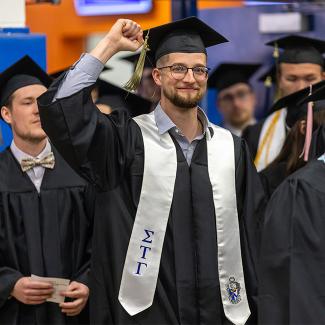 Happy LAE graduate punches fist into air in celebration