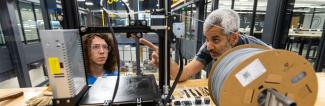 UW-Platteville student and faculty work with 3D printer
