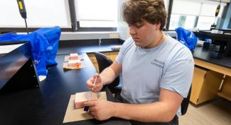 UW-Platteville student practices prepping a needle and injecting it.