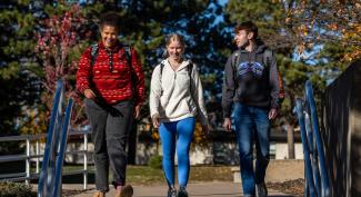 Group of smiling UW-Platteville students talk as they walk across campus