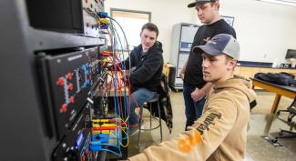 Three UW-Platteville Electrical Engineering students work together in lab