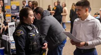 UW-Platteville student talks with a police officer at a career fair