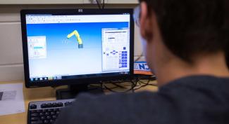 UW-Platteville student working on computer in robotics and controls lab