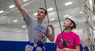 UW-Platteville student giving instructions on ropes course 