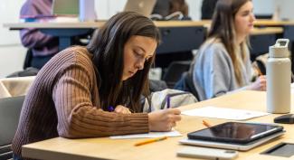 UW-Platteville student takes notes while in lecture.
