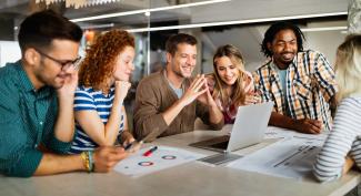 Young professionals in meeting around laptop