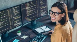 Professional woman coding on a multiple display computer setup