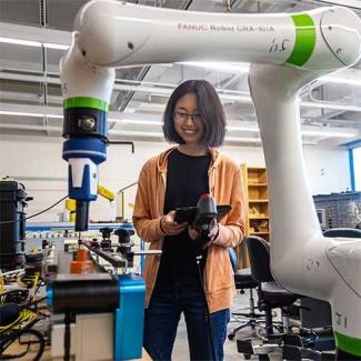 UW-Platteville student works in the IIOT lab with robotic arm