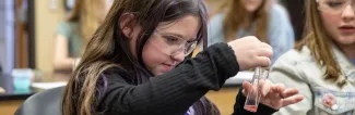 young girl does activity with pink liquid at UW-Platteville STEM EXPO