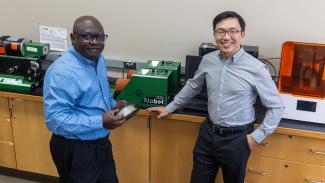 Dr. John Obielodan and Dr. Joseph Wu stand in lab