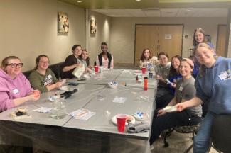 A group of smiling students sitting around a large table.