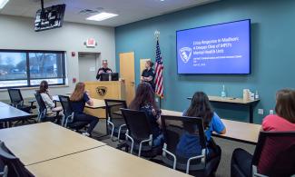 Participants in Women in Criminal Justice attend an event with speaker at front of room