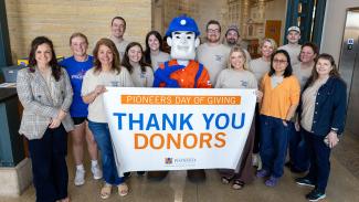 Smiling UW-Platteville staff hold up sign that says thank you donors.